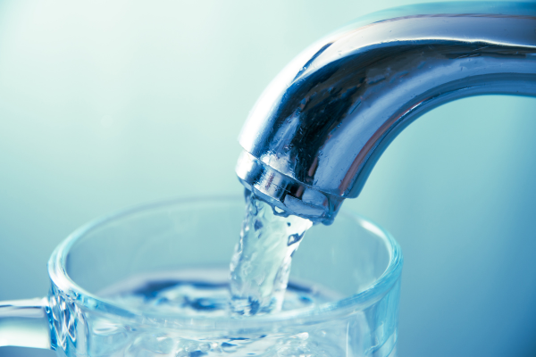 image of water flowing into glass from kitchen sink tap