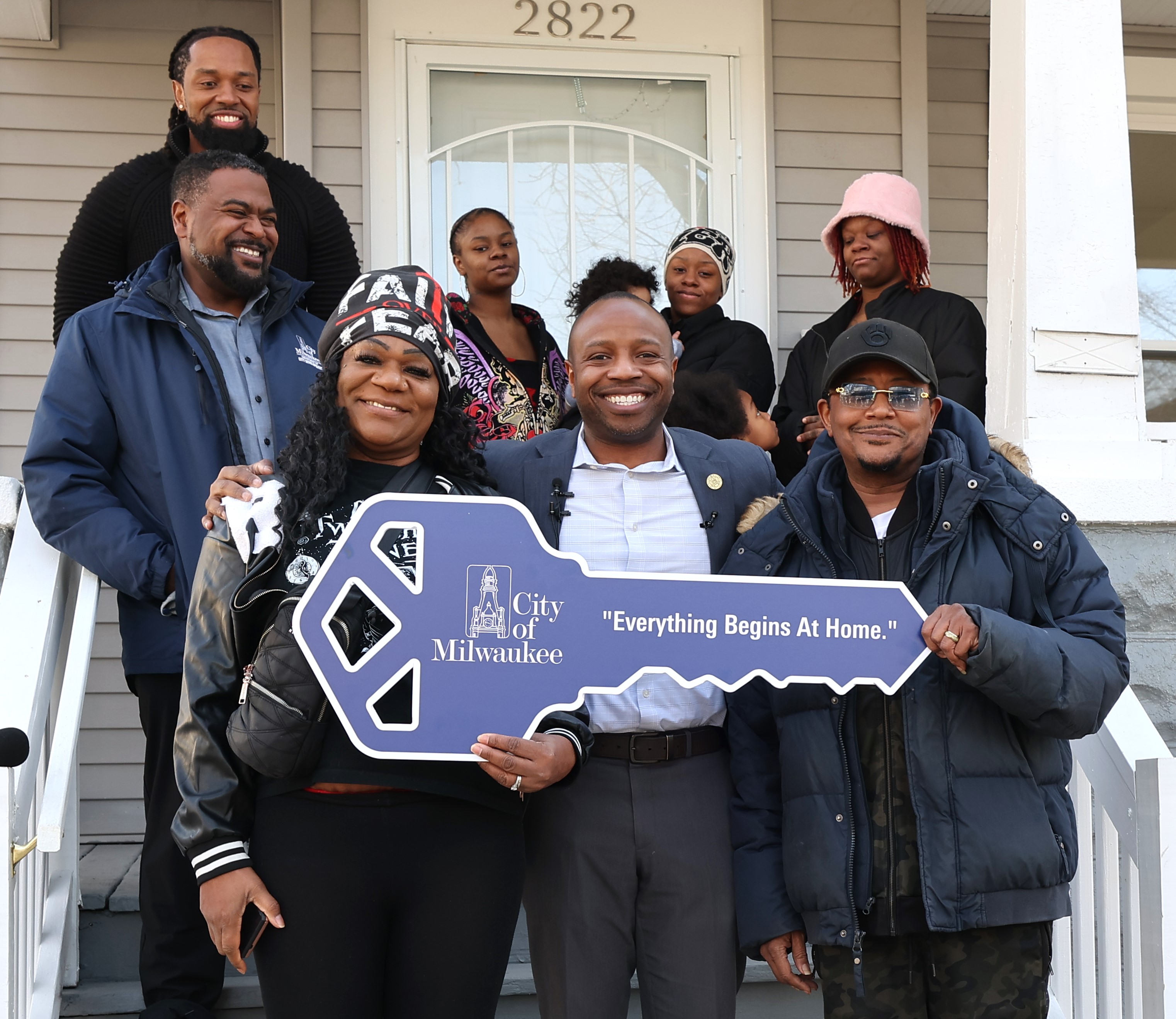 Mayor Johnson in photo with new homeowners holding giant house key