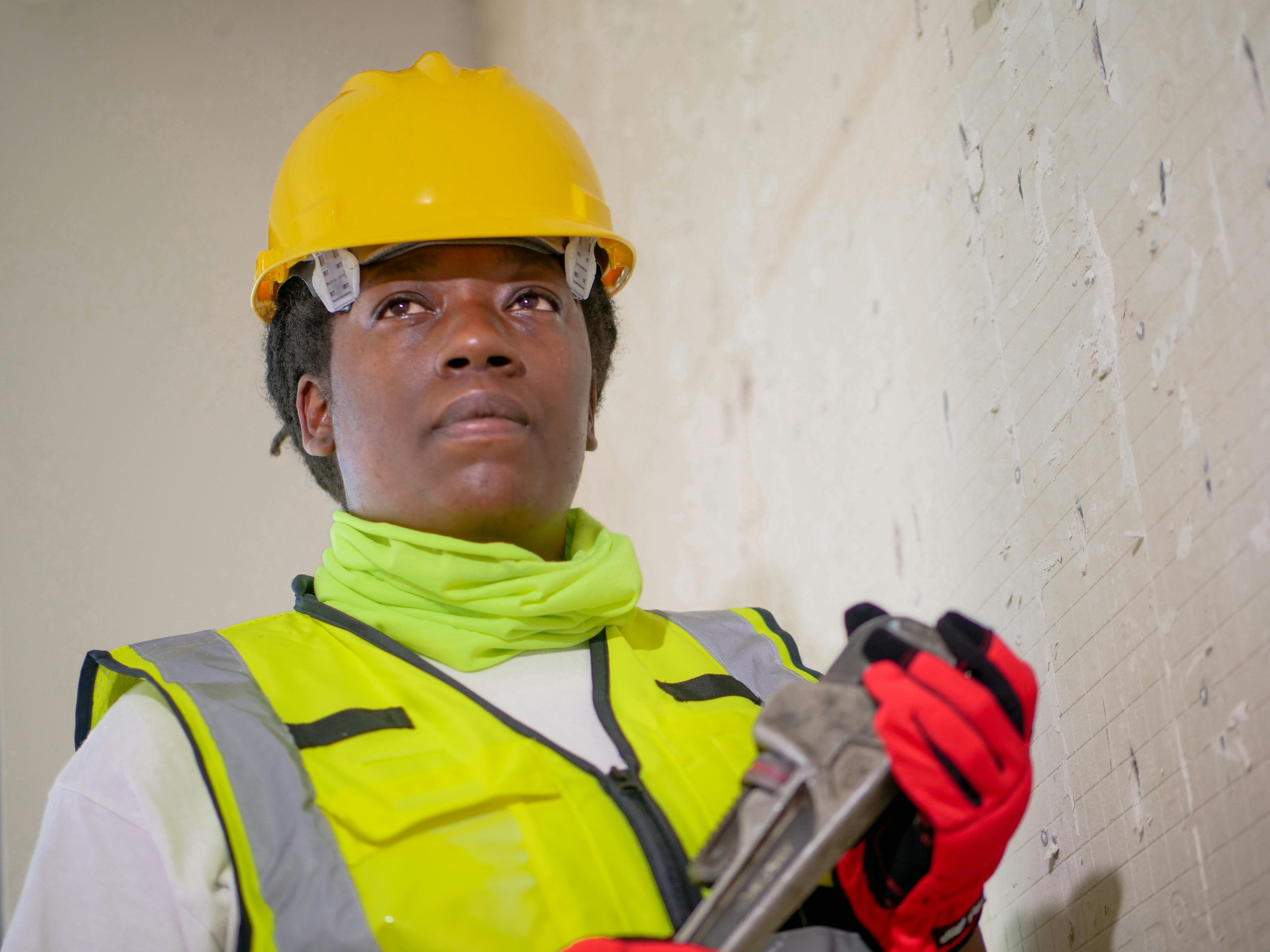 Person in hard hat holding a wrench