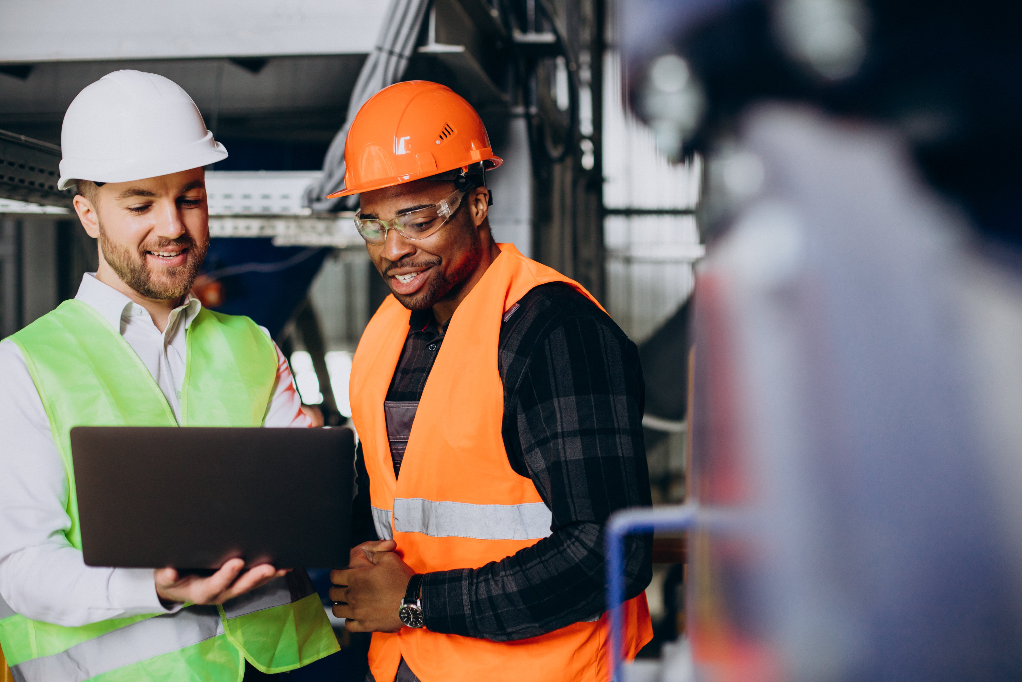 People in hard hats looking at a computer