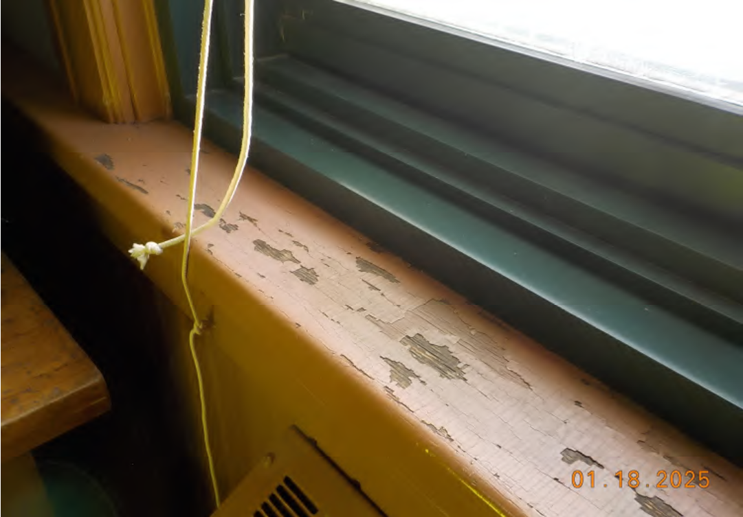 Detail photo showing chipped paint on elementary school window frame