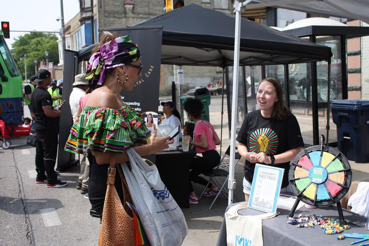 MKE Elevate team member speaks with a community resident during a summer festival