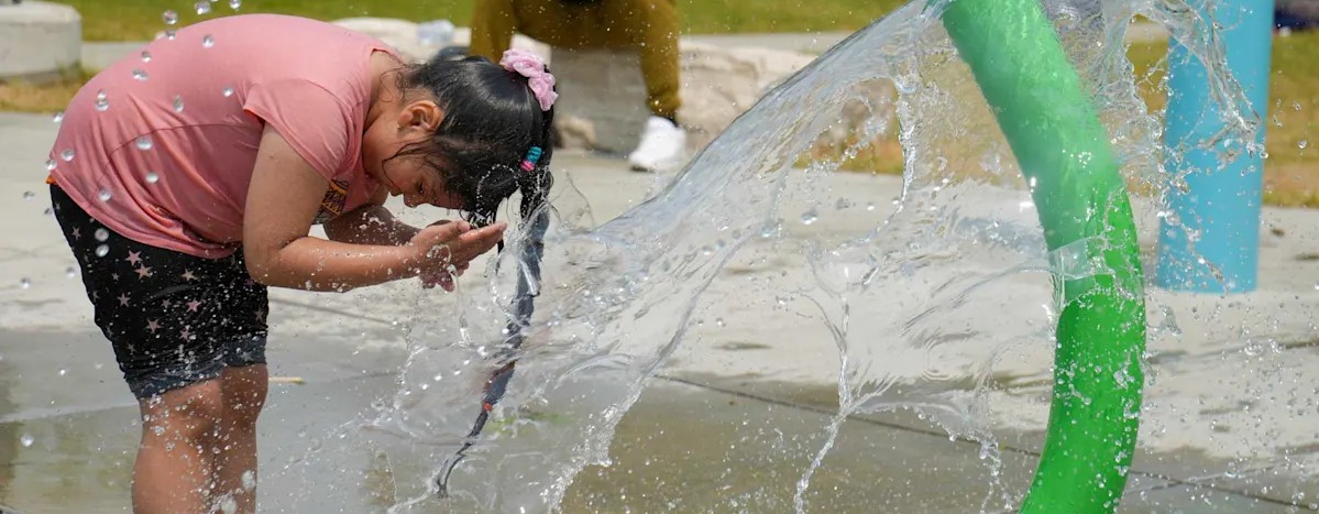 Child cools off under a splash pad