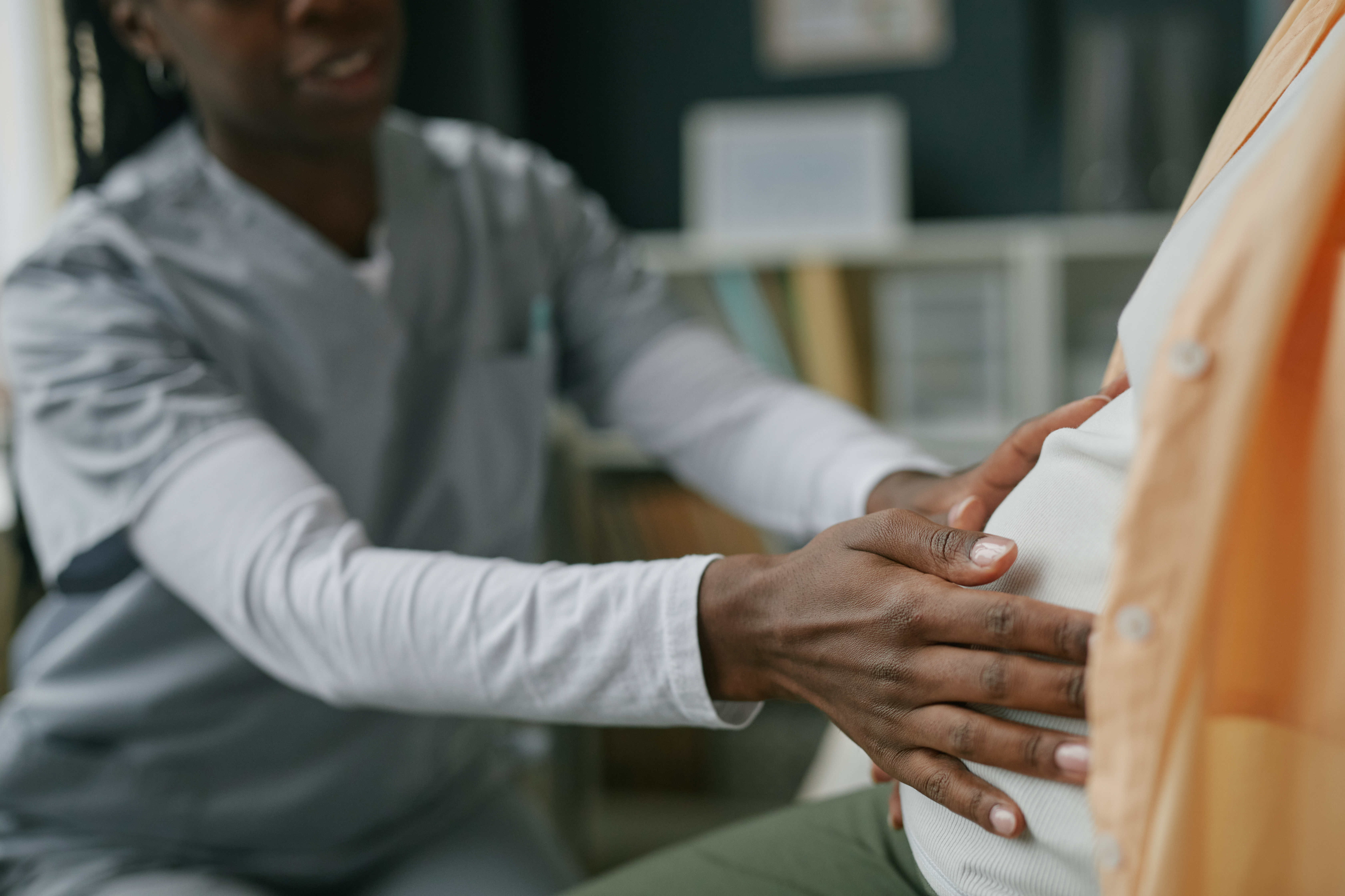 Pregnant person is examined by a medical professional