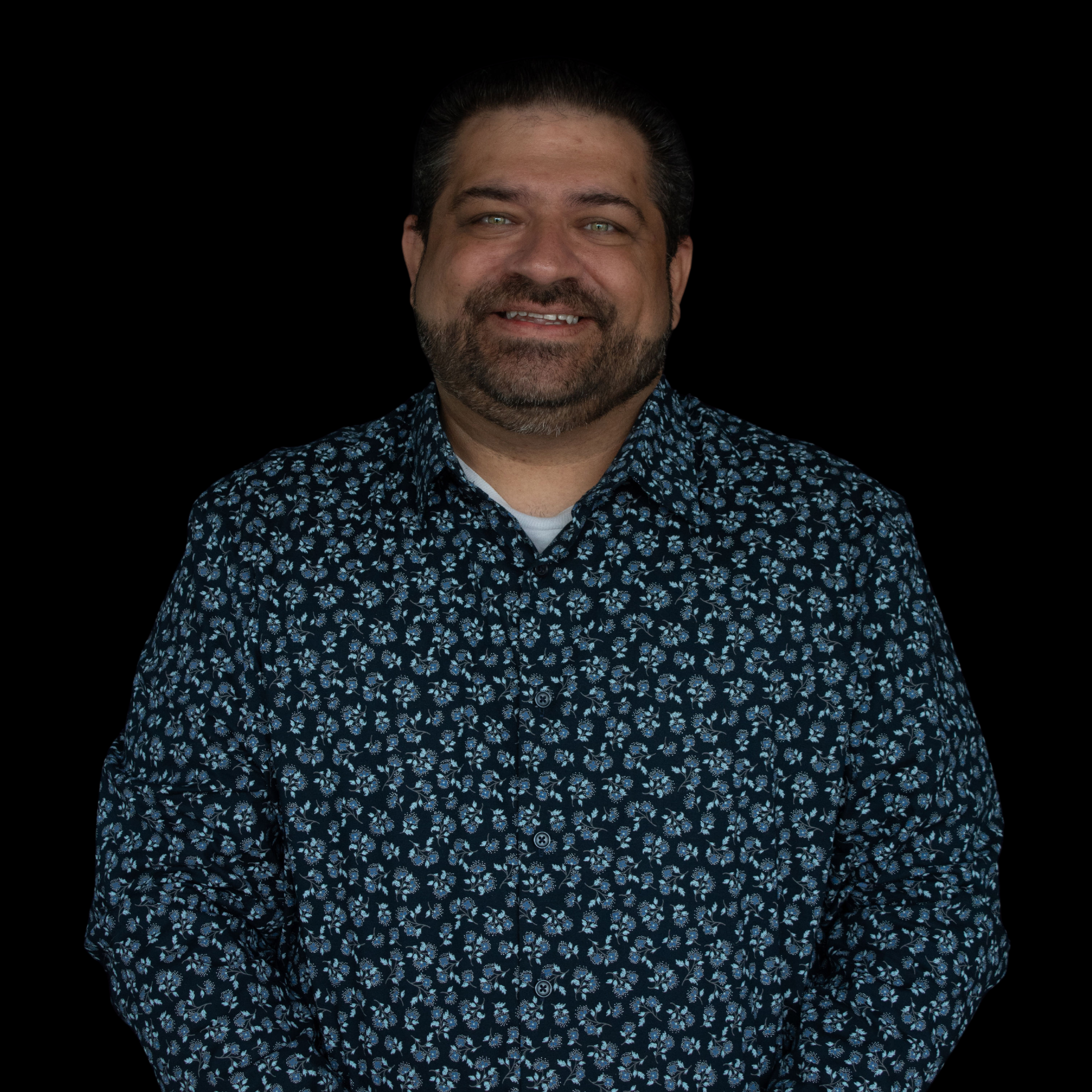 Man with blue smiles in a blue floral shirt