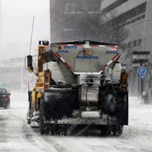Image of a City of Milwaukee truck  salting and plowing a residential street.