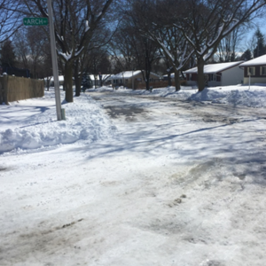 image of residential street after a truck has plowed the snow.