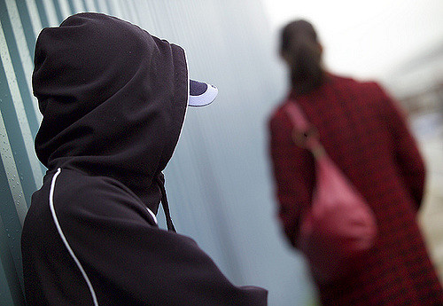 Image of woman walking with purse and a possible mugging